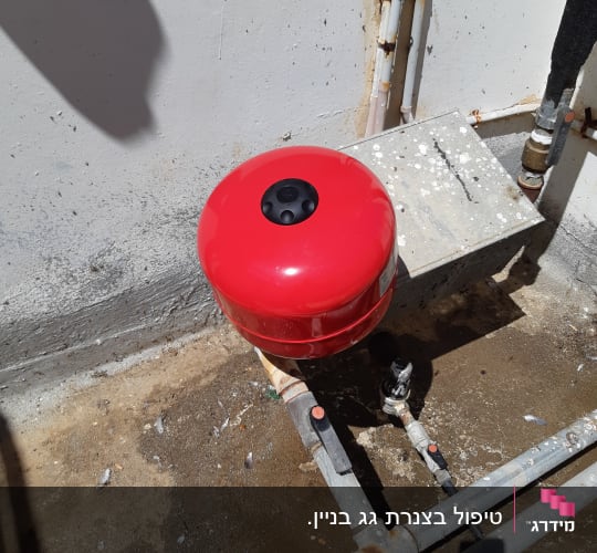 מיכל לחץ אדום וצינורות מתכת עם ברזים